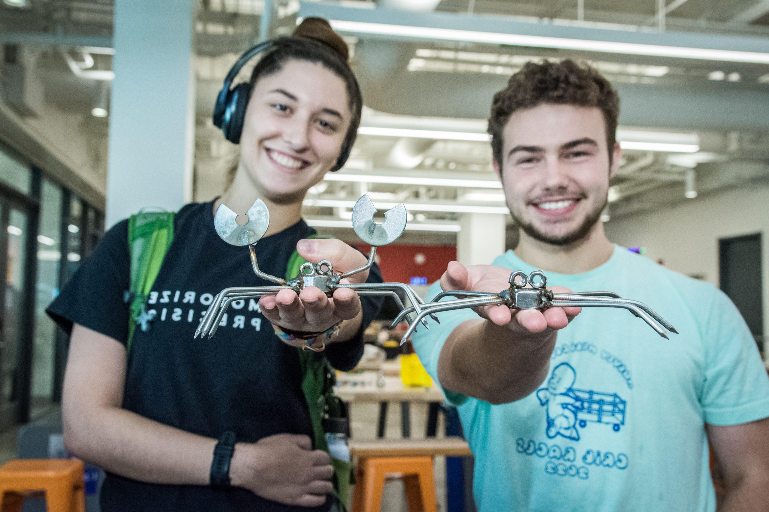 学生 holding up welded metal crabs.